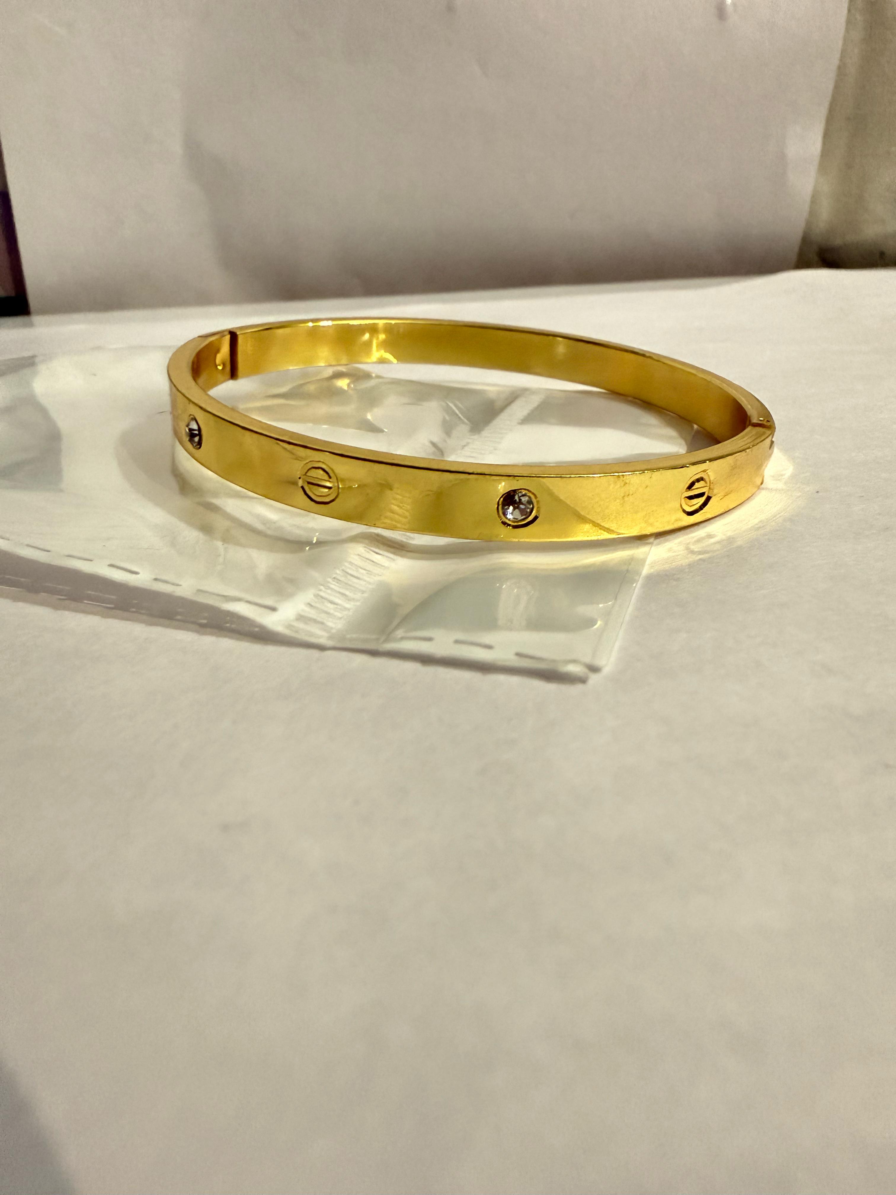 Elegance in Simplicity: A Gold-Toned Bangle Bracelet with Diamond Accents